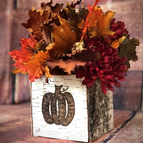 Fall pumpkin centerpiece with mums and maple leaves